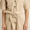 Damen-Jumpsuit aus beigem Denim mit Gürtel und ausgefranstem Saum Damen-Jumpsuit aus beigem Denim mit Gürtel und ausgefranstem Saum