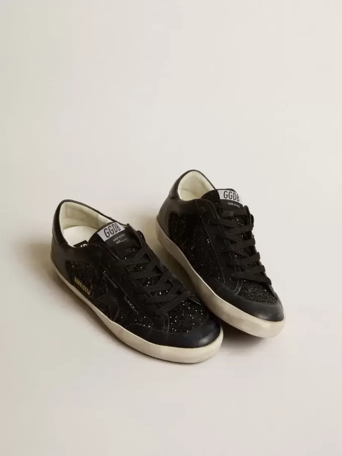 Damen-Superstar aus schwarzem Nappa und Glitzer mit glänzendem schwarzen Lederstern Damen-Superstar aus schwarzem Nappa und Glitzer mit glänzendem schwarzen Lederstern