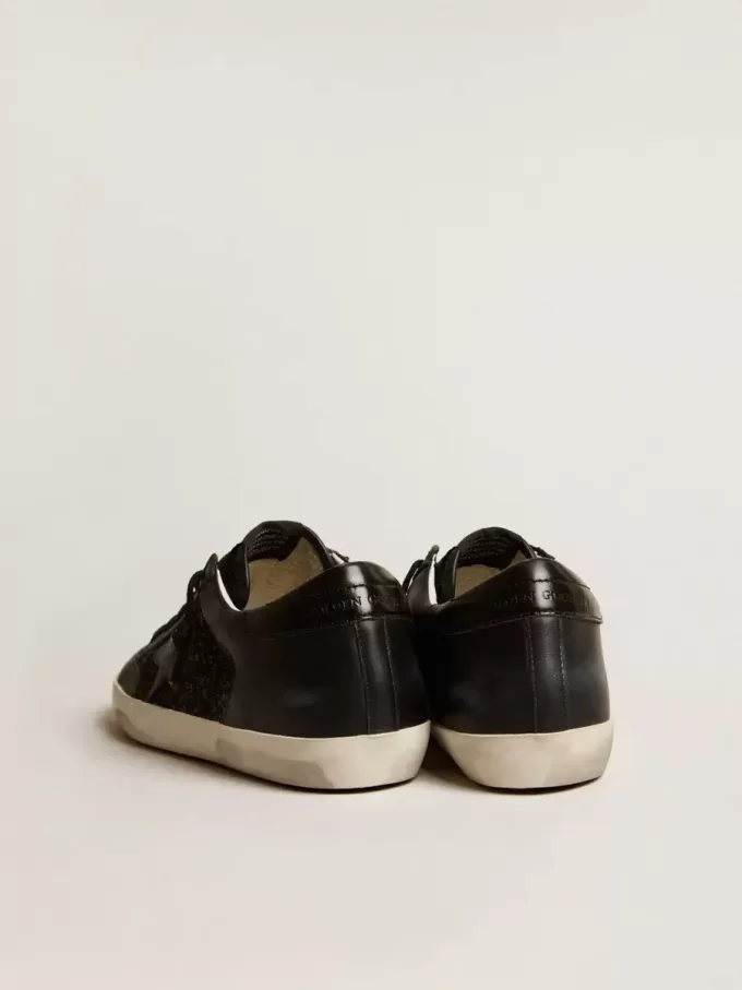 Damen-Superstar aus schwarzem Nappa und Glitzer mit glänzendem schwarzen Lederstern Damen-Superstar aus schwarzem Nappa und Glitzer mit glänzendem schwarzen Lederstern