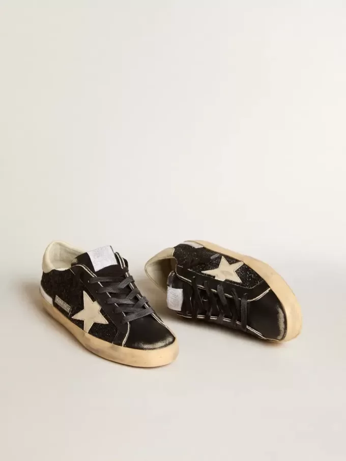 Damen-Superstar in schwarzem Glitzer und Nappa mit cremefarbenem Lederstern und Fersenlasche Damen-Superstar in schwarzem Glitzer und Nappa mit cremefarbenem Lederstern und Fersenlasche