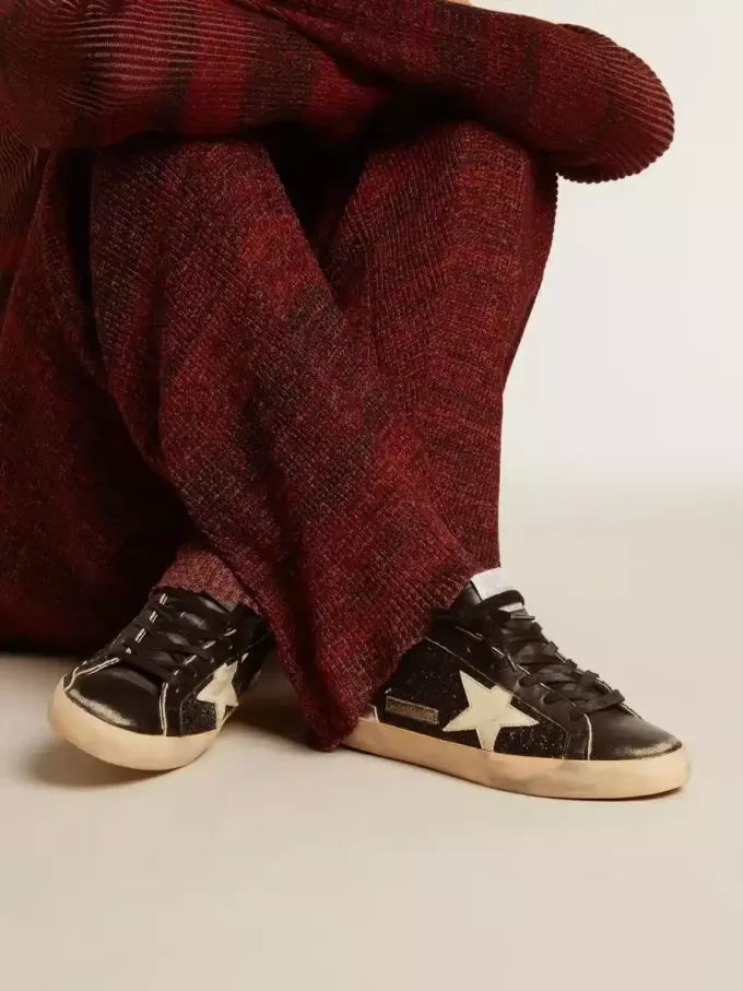 Damen-Superstar in schwarzem Glitzer und Nappa mit cremefarbenem Lederstern und Fersenlasche Damen-Superstar in schwarzem Glitzer und Nappa mit cremefarbenem Lederstern und Fersenlasche