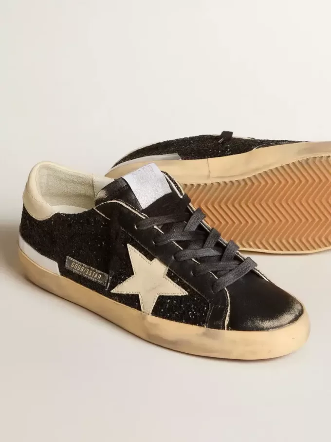 Damen-Superstar in schwarzem Glitzer und Nappa mit cremefarbenem Lederstern und Fersenlasche Damen-Superstar in schwarzem Glitzer und Nappa mit cremefarbenem Lederstern und Fersenlasche