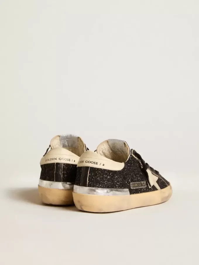 Damen-Superstar in schwarzem Glitzer und Nappa mit cremefarbenem Lederstern und Fersenlasche Damen-Superstar in schwarzem Glitzer und Nappa mit cremefarbenem Lederstern und Fersenlasche