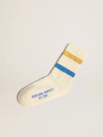 Getragene weiße Kindersocken mit Used-Details und zweifarbigen Streifen in leuchtendem Blau und Senfgelb
