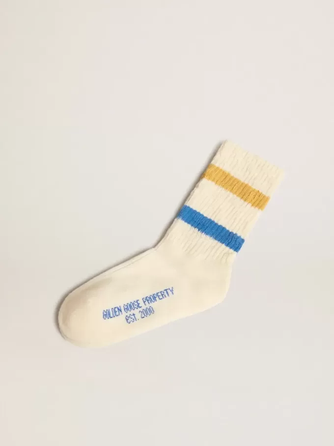 Getragene weiße Kindersocken mit Used-Details und zweifarbigen Streifen in leuchtendem Blau und Senfgelb
