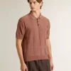 Herren-Polo in Ziegelrot mit gesticktem Logo.