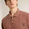 Herren-Polo in Ziegelrot mit gesticktem Logo.