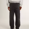 Herrenjeans aus schwarzem Baumwollstoff im Distressed-Look mit Aufnähern auf der Vorderseite