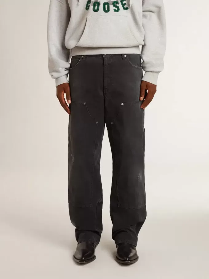 Herrenjeans aus schwarzem Baumwollstoff im Distressed-Look mit Aufnähern auf der Vorderseite